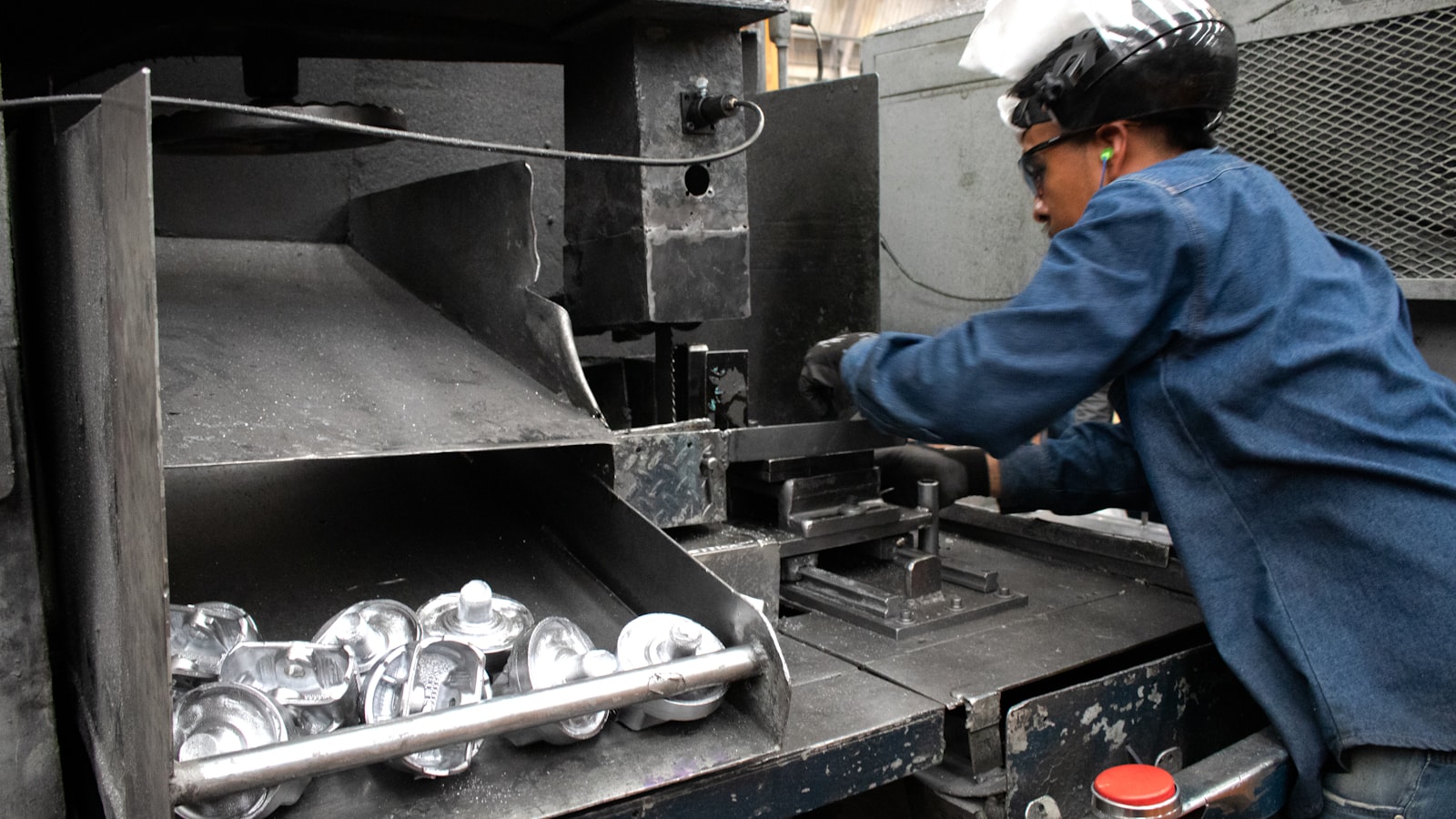 An operator working a panel across a machine bed.